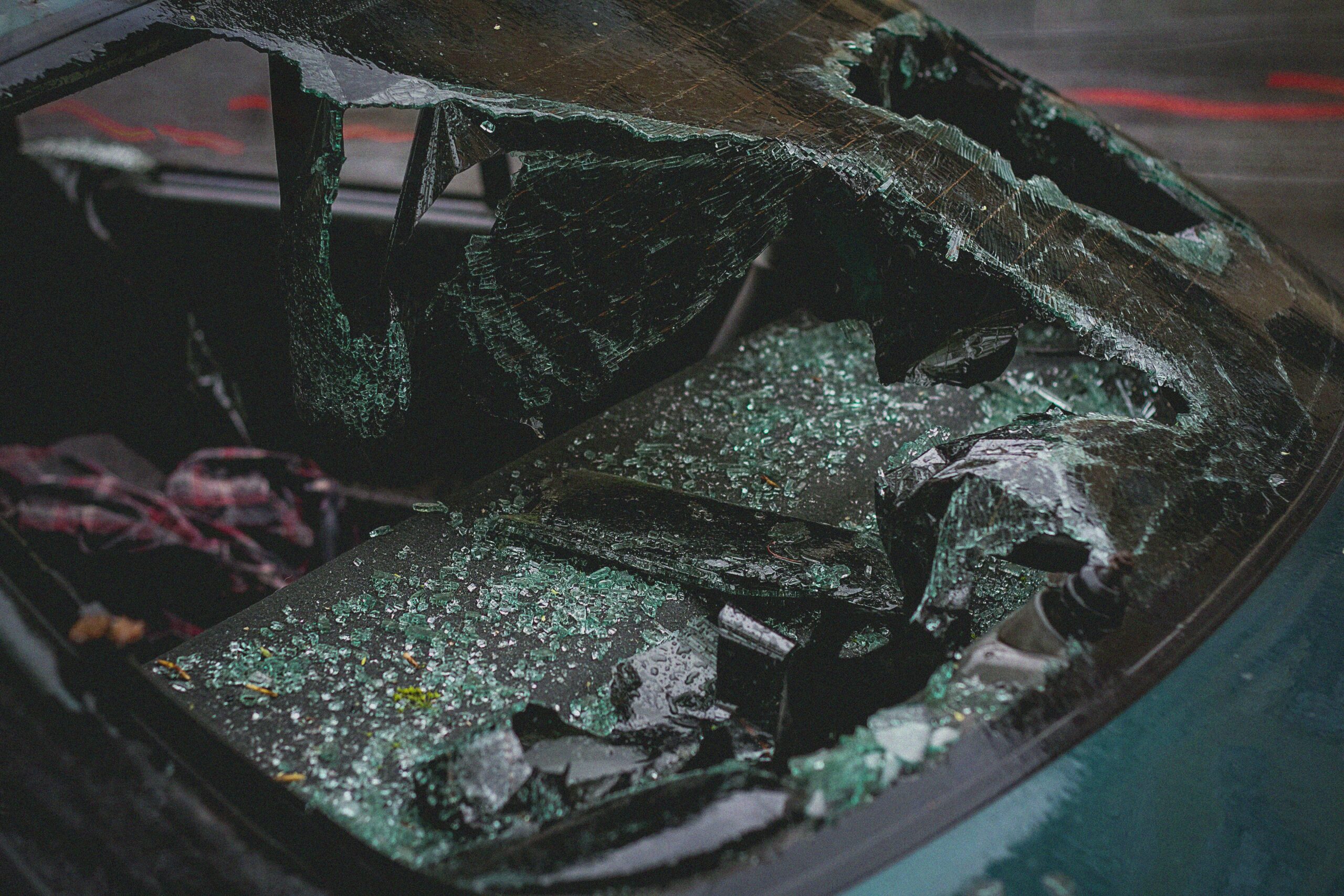 Home Detailed view of shattered car windshield after accident, emphasizing damage and broken glass.
